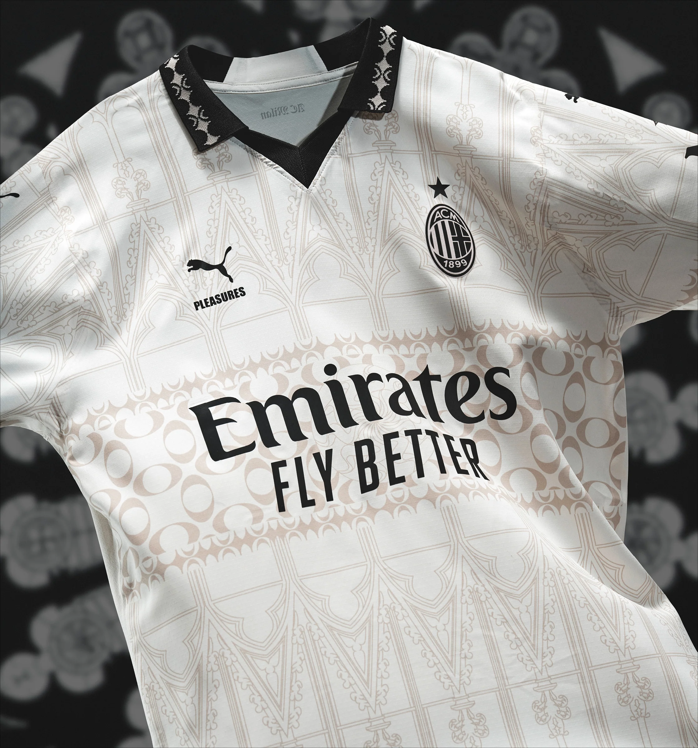 Gros plan sur un élégant maillot de football de l'AC Milan, blanc avec un motif graphique détaillé, sponsorisé par "Emirates Fly Better", avec un logo Puma noir et blanc et un col à motif noir.