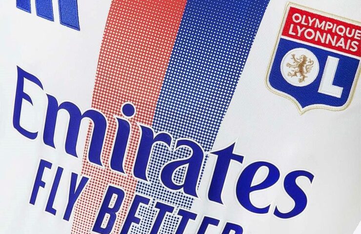 Close-up of the Olympique Lyonnais 2024/2025 home shirt with Emirates logo and red and blue gradient