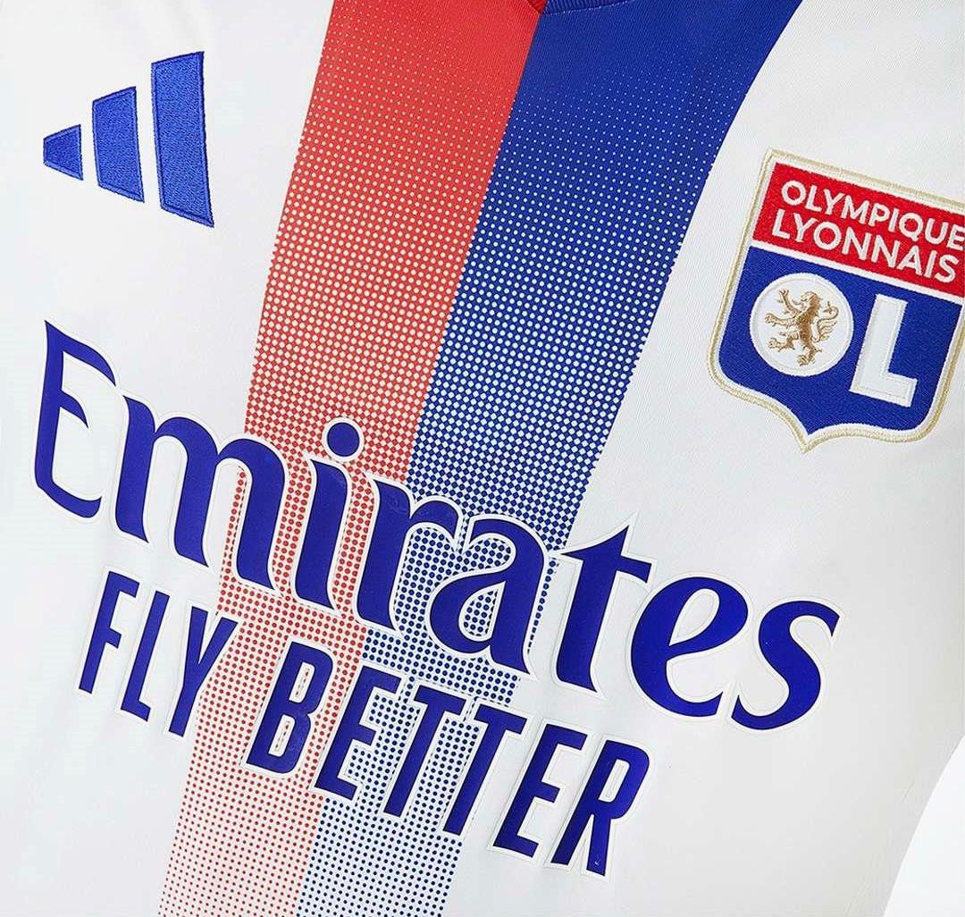 Close-up of the Olympique Lyonnais 2024/2025 home shirt with Emirates logo and red and blue gradient